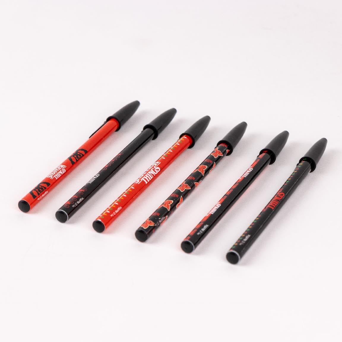Stranger Things Kugelschreiber, 6 Stück, verschiedene Designs in Rot und Schwarz, mit Deckel in Schwarz, 100 % ABS-Kunststoff, Originalprodukt, entworfen in Spanien