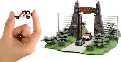 Jada- Jurassic Park Nanoescenario Puerta de Parque Jurásico, Especial 30 Aniversario de la Película Original, Con 2 Nanovehículos Metálicos de 4cm y 3 Dinosaurios (253252028)