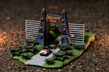 Jada- Jurassic Park Nanoescenario Puerta de Parque Jurásico, Especial 30 Aniversario de la Película Original, Con 2 Nanovehículos Metálicos de 4cm y 3 Dinosaurios (253252028)